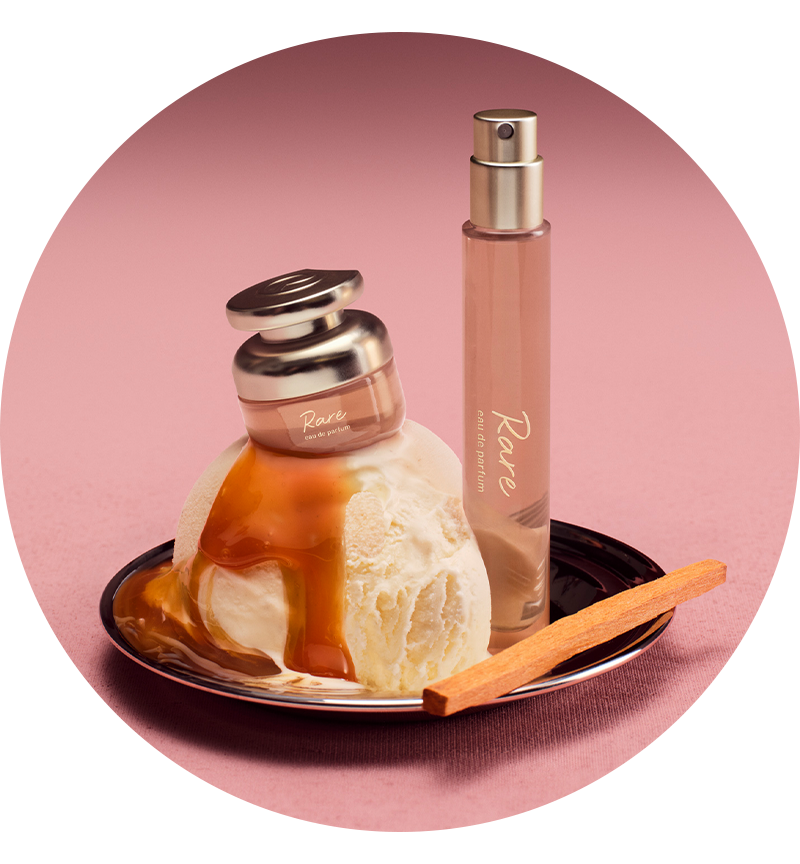 Perfume bottle with ice cream and a cinnamon stick on a pink background